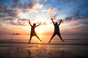 couple jump sunset-shutterstock_124714891